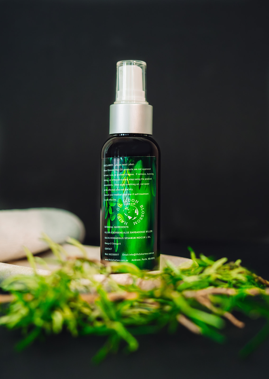 Close up of the Moon Blossom Hair Oil 100ml amber spray bottle label